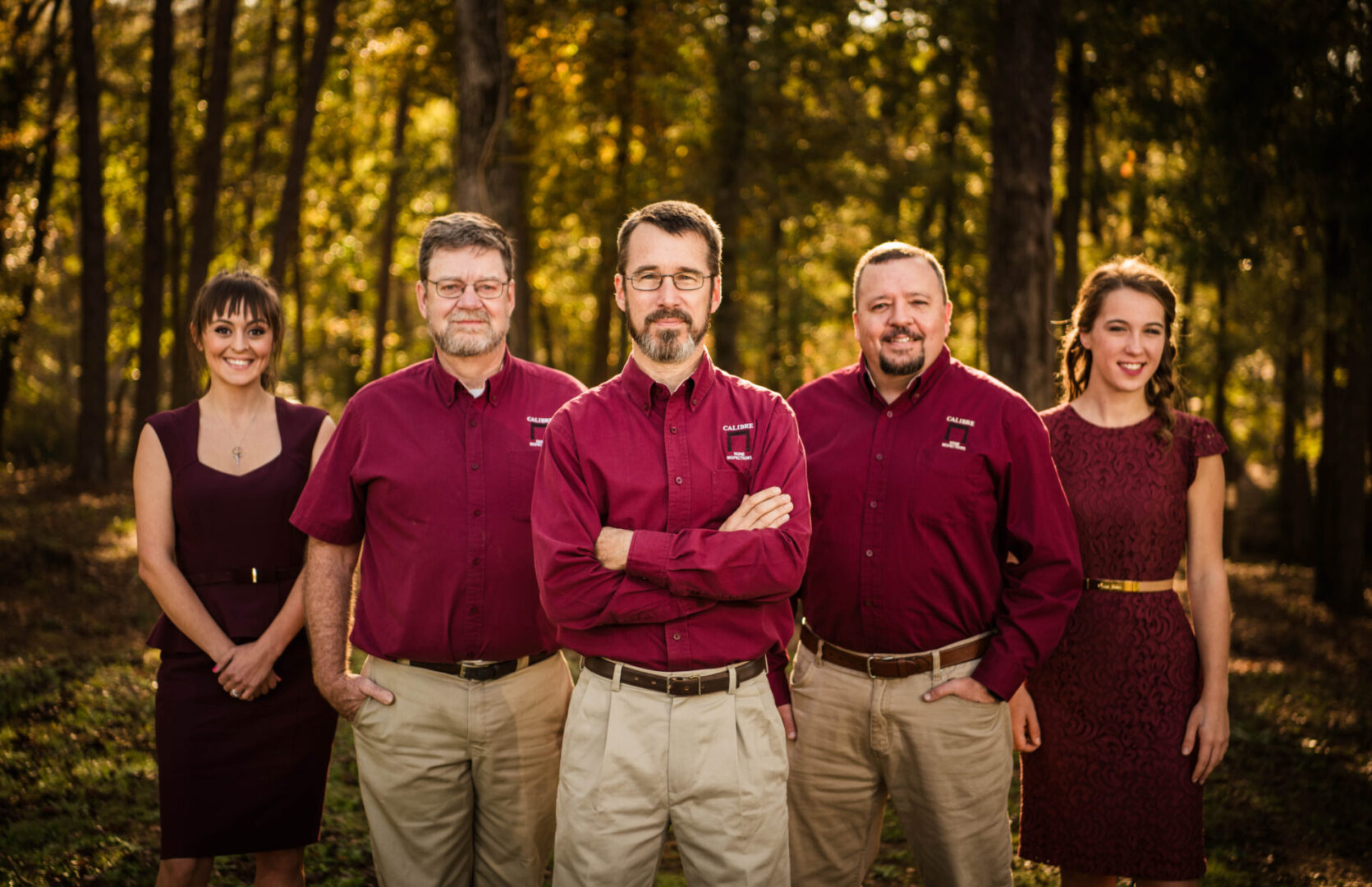 A group of people standing in front of trees.