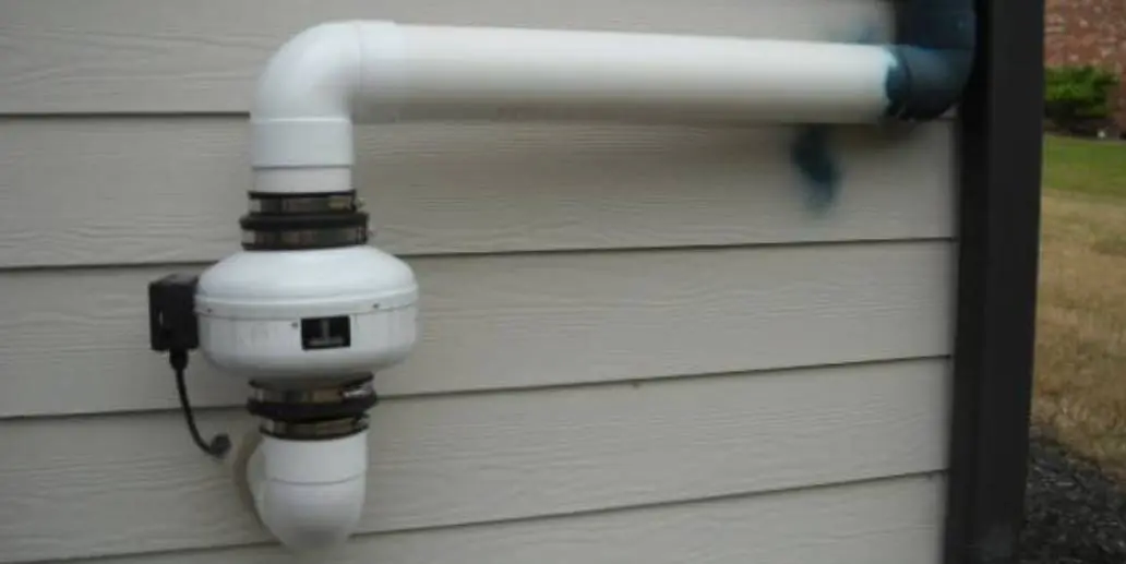 A white pipe on the side of a house.