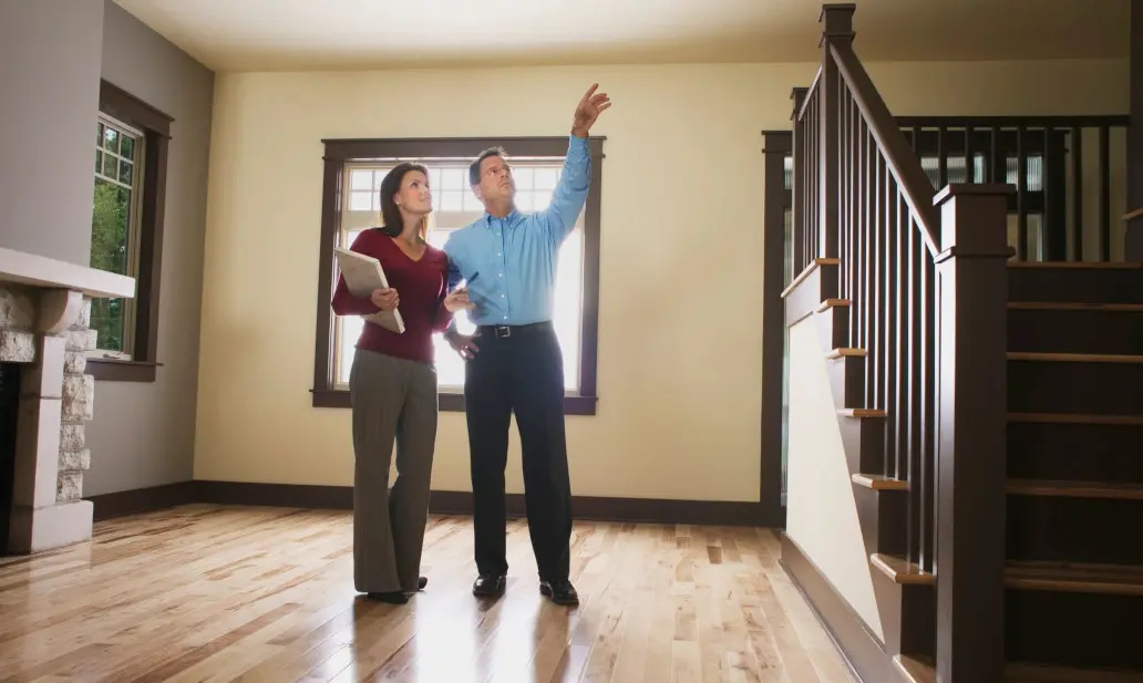 A man and woman standing in front of a staircase.